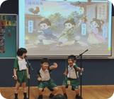 Students performing a Chinese language role-play in front of the class.
