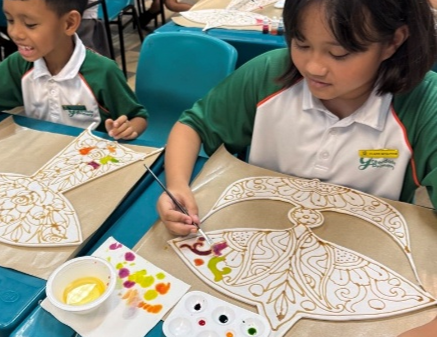 Student painting a traditional Malay-inspired art design in class.