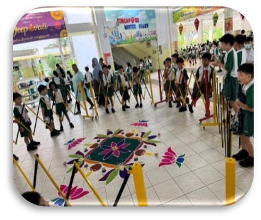 Students viewing a colourful kolam display during a school cultural event.
