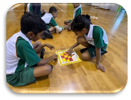 Students playing a Tamil language board game during a learning activity.