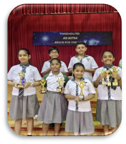 Students proudly displaying trophies at a school awards ceremony.